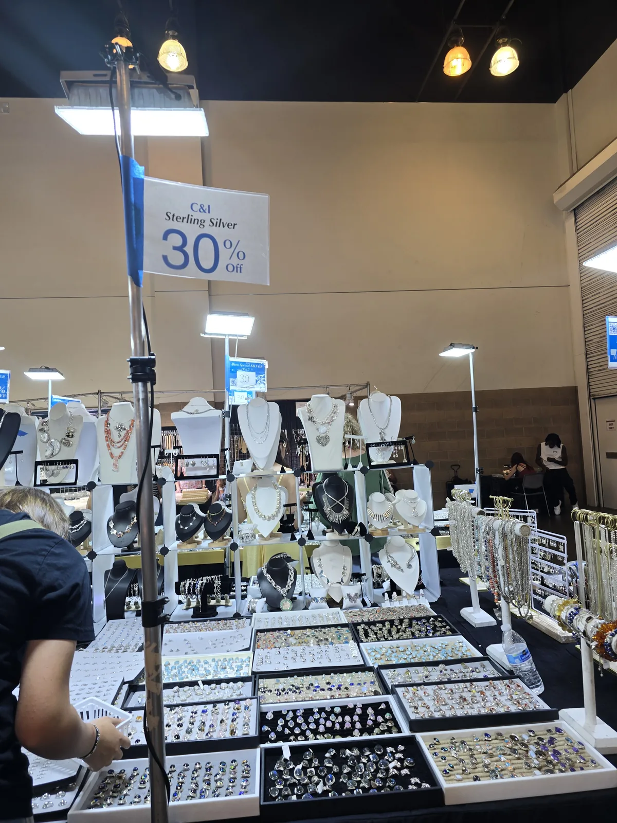 InterGem 展会 C&I Sterling Silver 摊位,高挂 30% Off 蓝牌,底下整桌宝石戒指一托一托摆